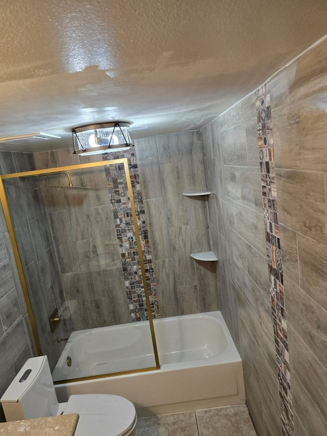 Bathroom tub and shower with tile surround and glass